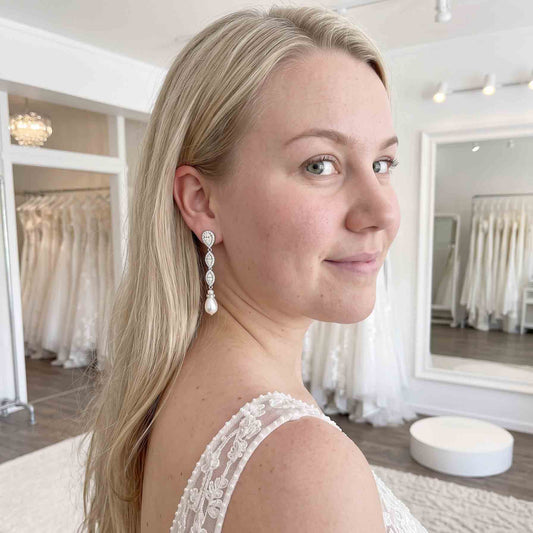Model Bride wearing Abby silver crystal and pearl drop earrings with loose hair and a lace wedding dress.