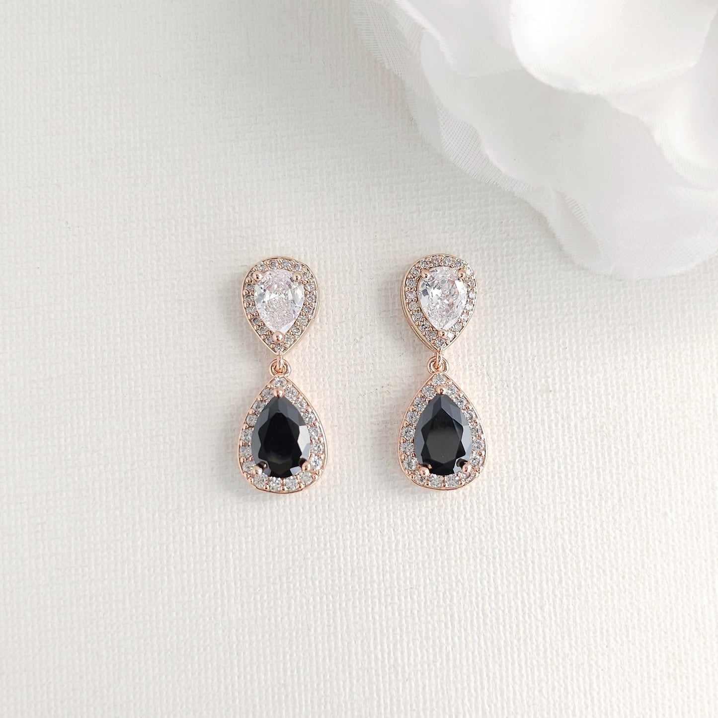 Teardrop-shaped earrings with black CZ stones on a white background